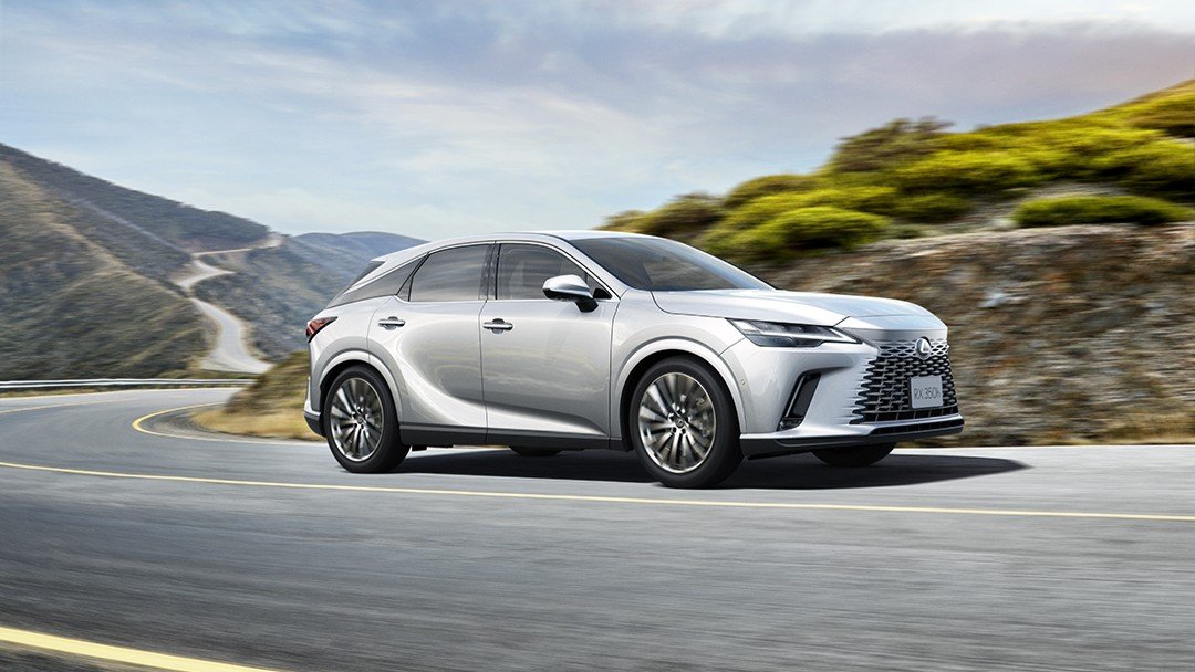 Silver Lexus RX driving on a coastal mountain road