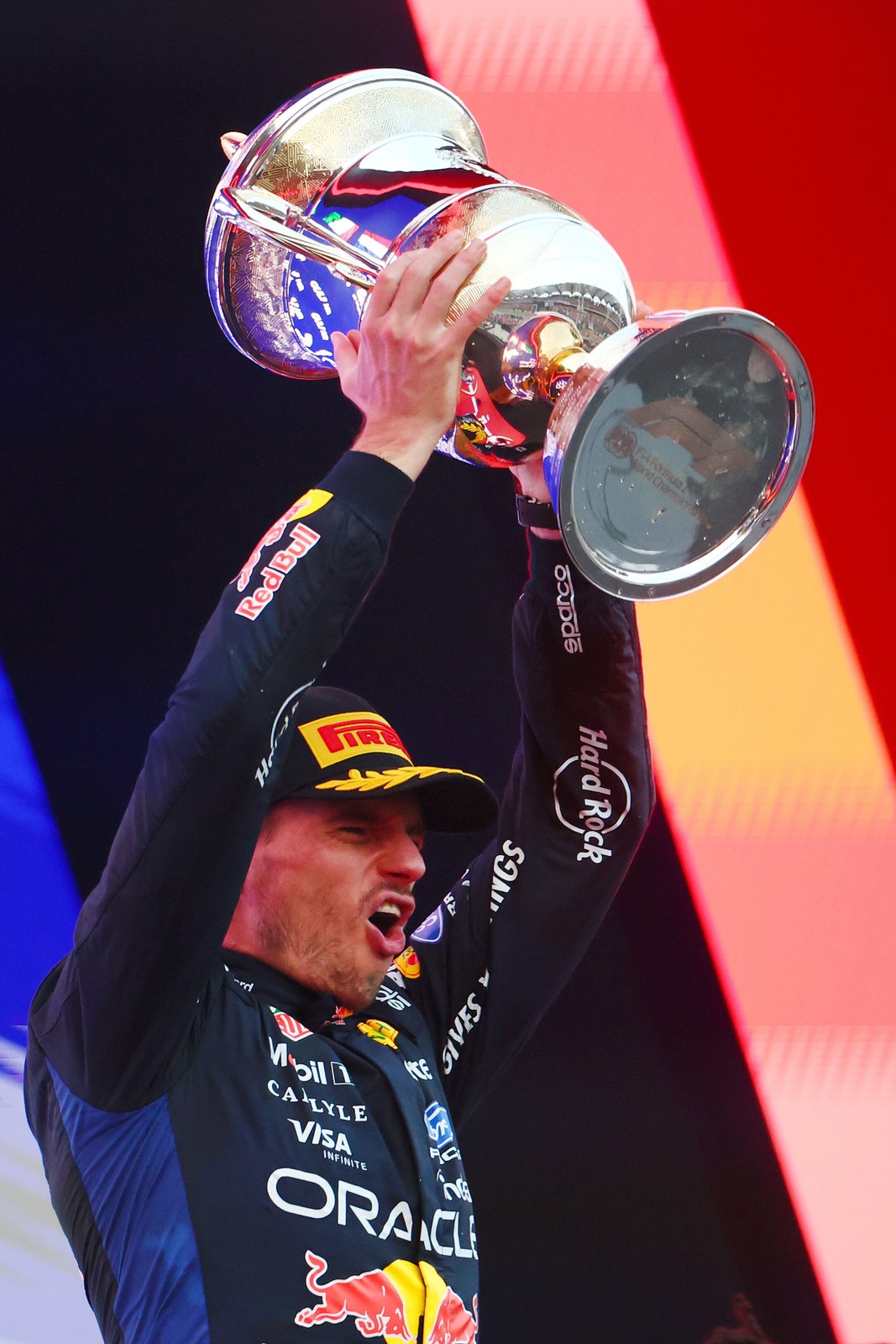 Max Verstappen lifts the winner’s trophy on the Sepang podium