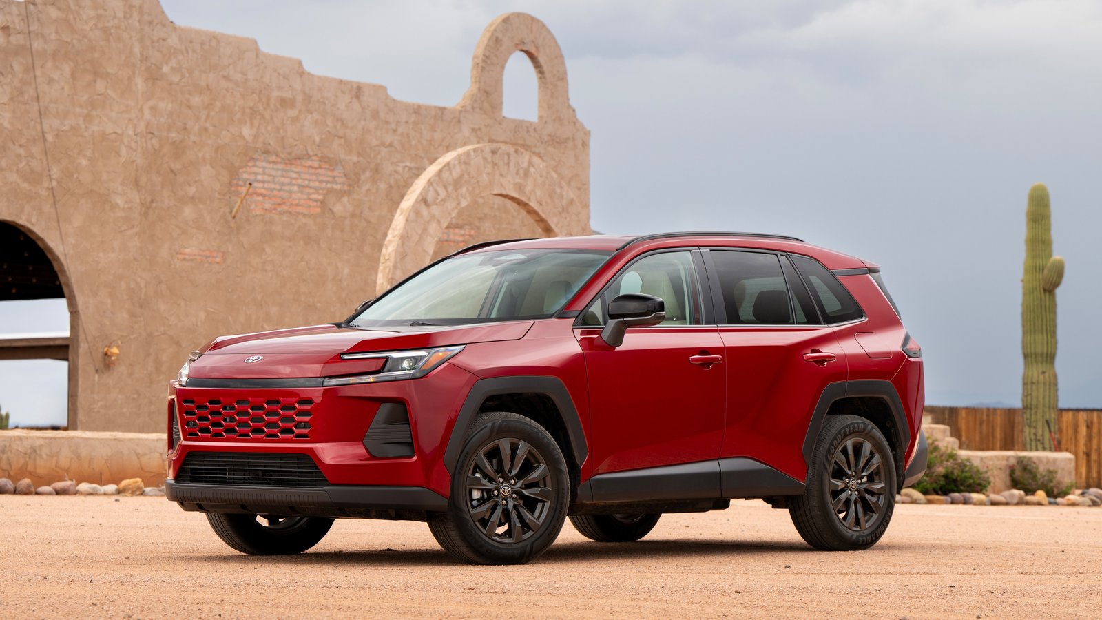 Red 2026 Toyota RAV4 parked in front of an adobe building