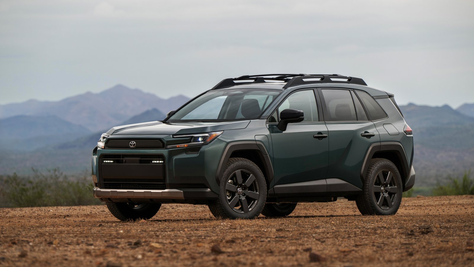 Green 2026 Toyota RAV4 Woodland parked on a dirt lot, front three-quarter view
