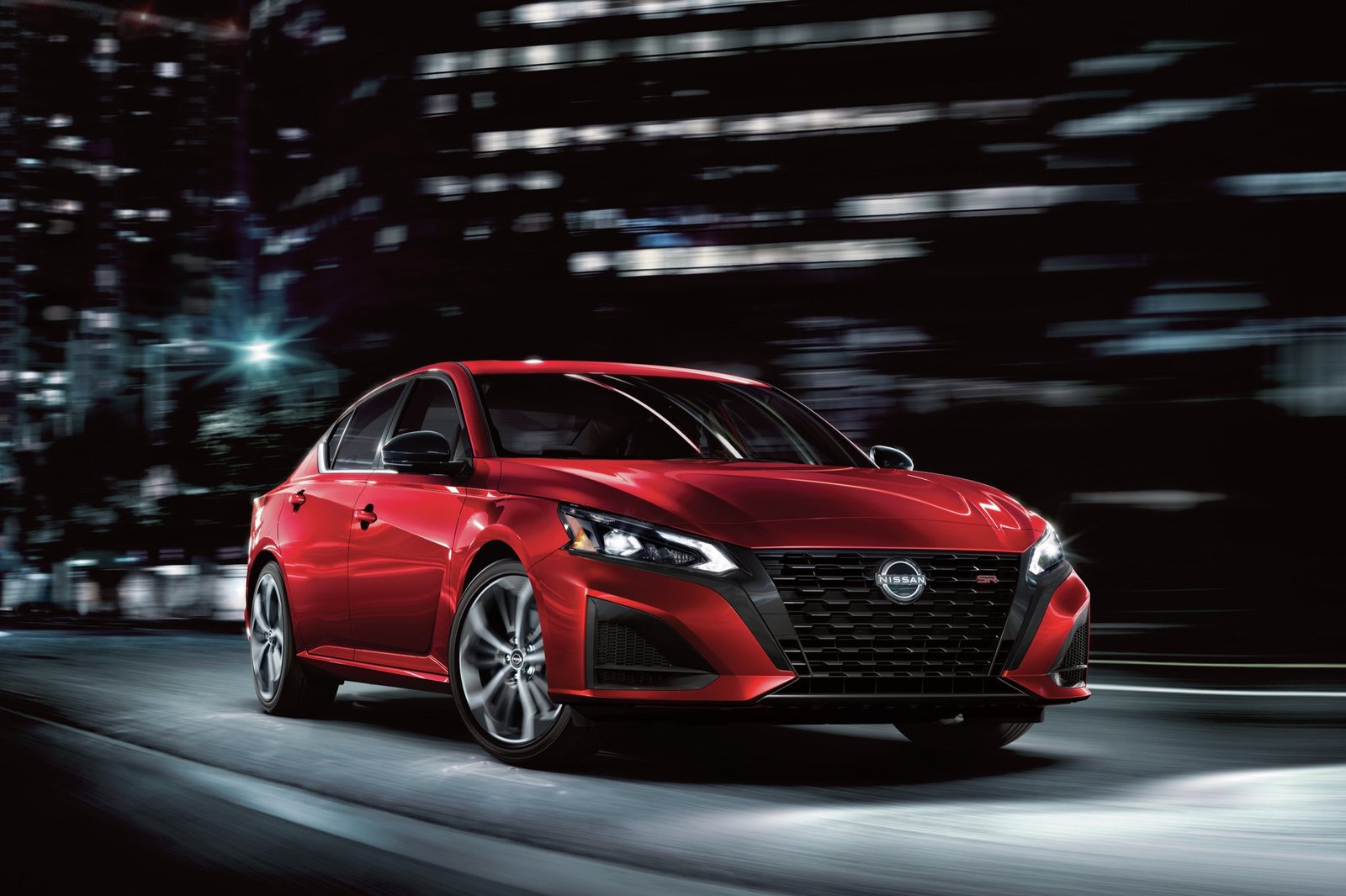 2027 Nissan Altima SR driving through a city at night, front three-quarter view
