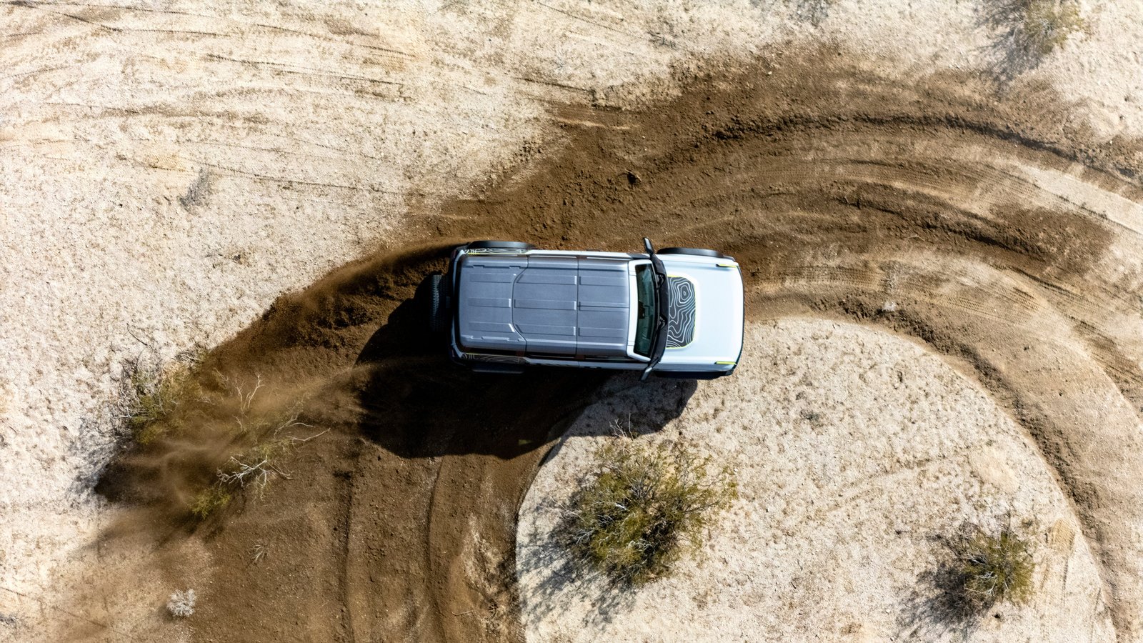 Drone shot of Bronco RTR carving a circle in desert sand