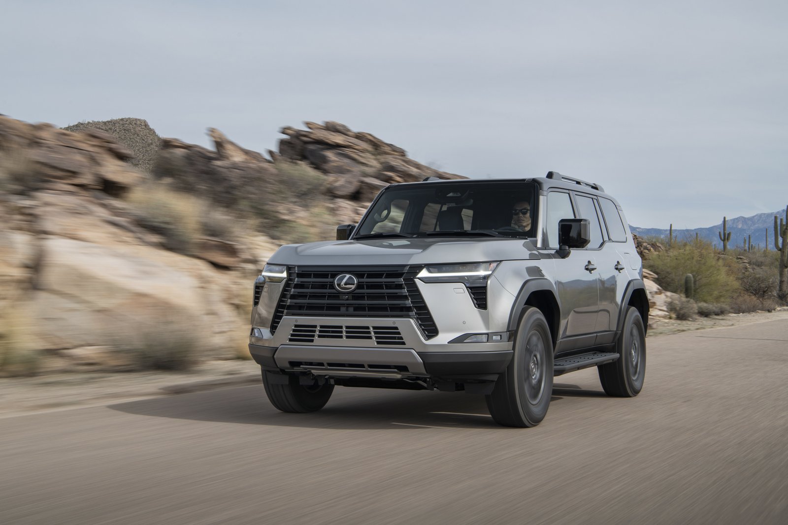 2027 Lexus GX Overtrail in silver driving on a desert road