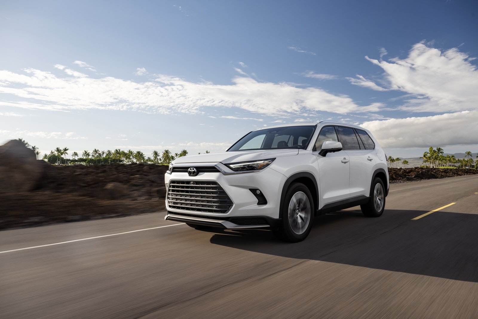 White 2027 Toyota Grand Highlander Limited driving on a coastal road