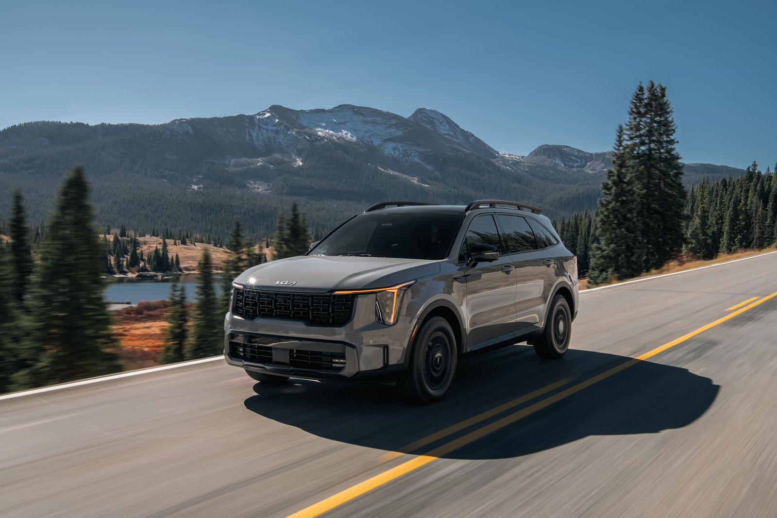 With destination included…». alt: "2027 Kia Sorento driving on a mountain highway