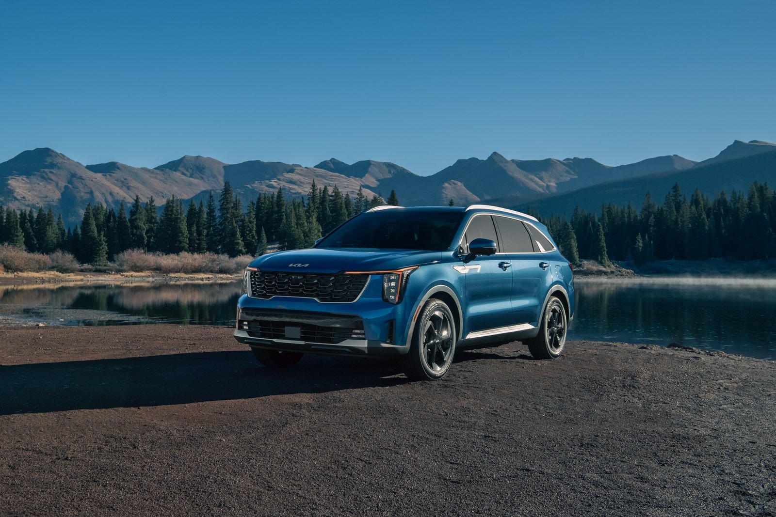 2027 Kia Sorento Hybrid EX parked beside an alpine lake, front three-quarter view