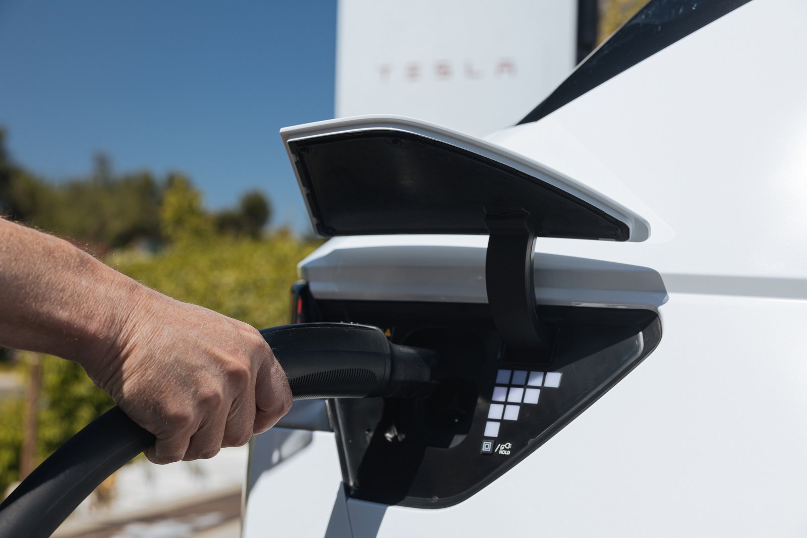 Hyundai Motor America". Alt: "Driver plugs a Tesla Supercharger connector into a white Hyundai Ioniq 5