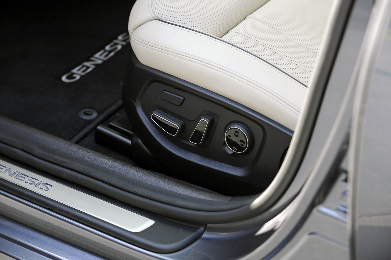 Close-up of power seat slider and height switches on a Genesis front seat