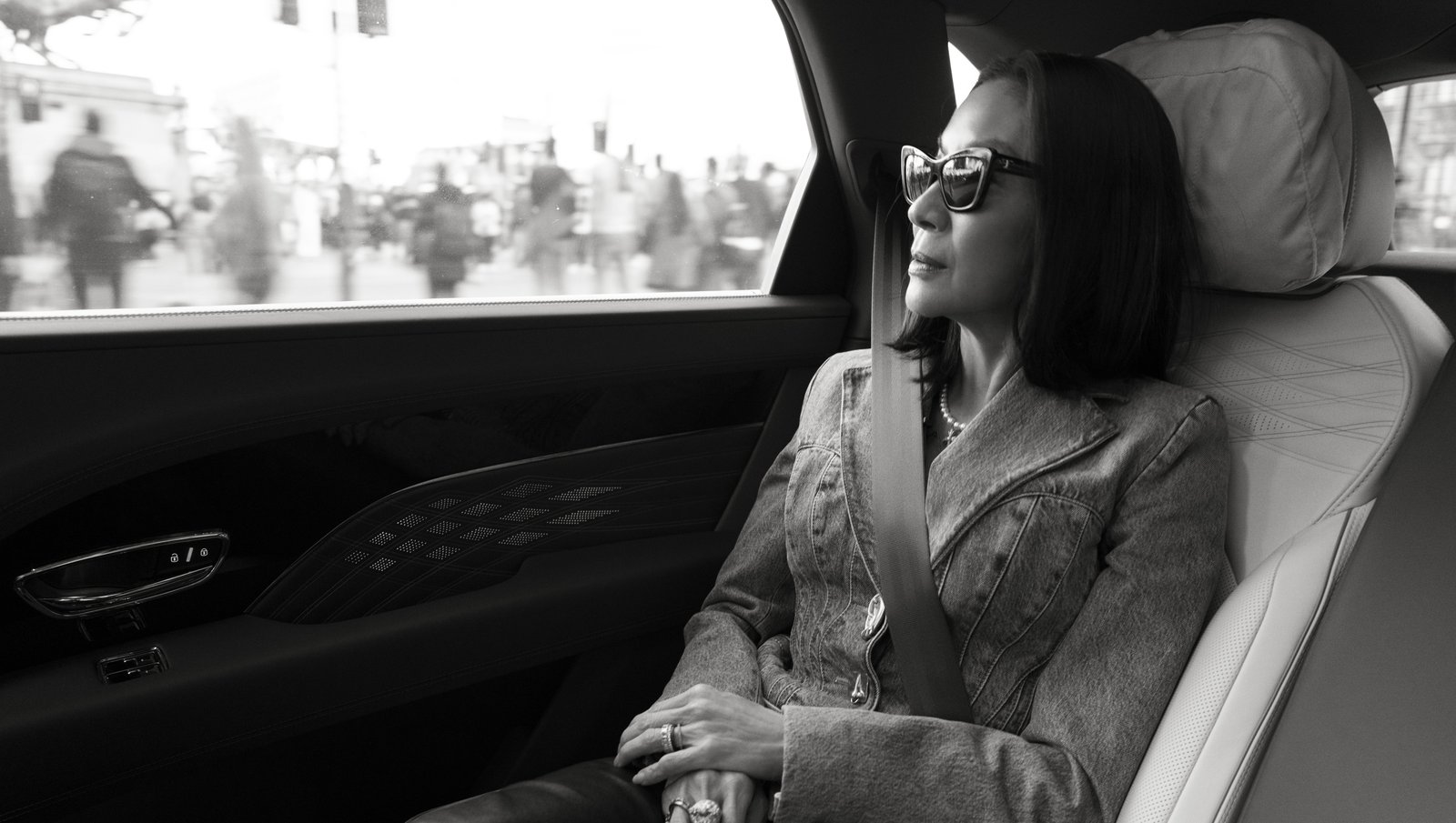 Michelle Yeoh looking out of a Bentley window, quilted door trim visible