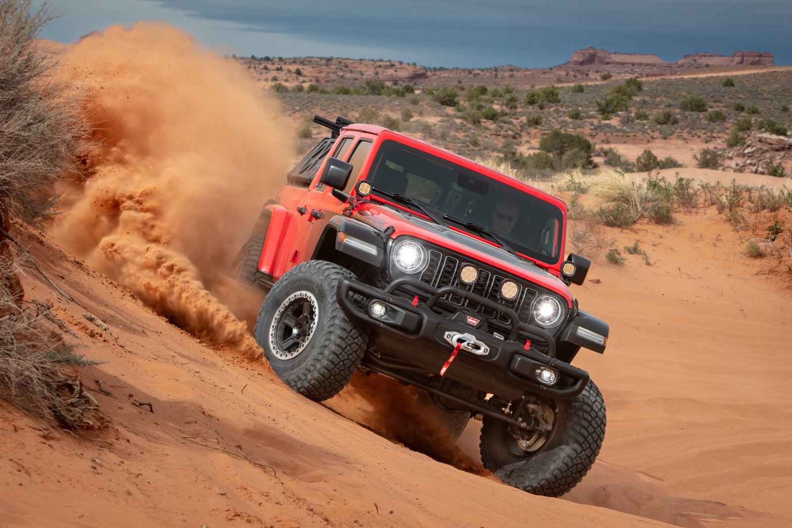 Red Jeep Gladiator Red Rock Concept climbing a sand hill near Moab