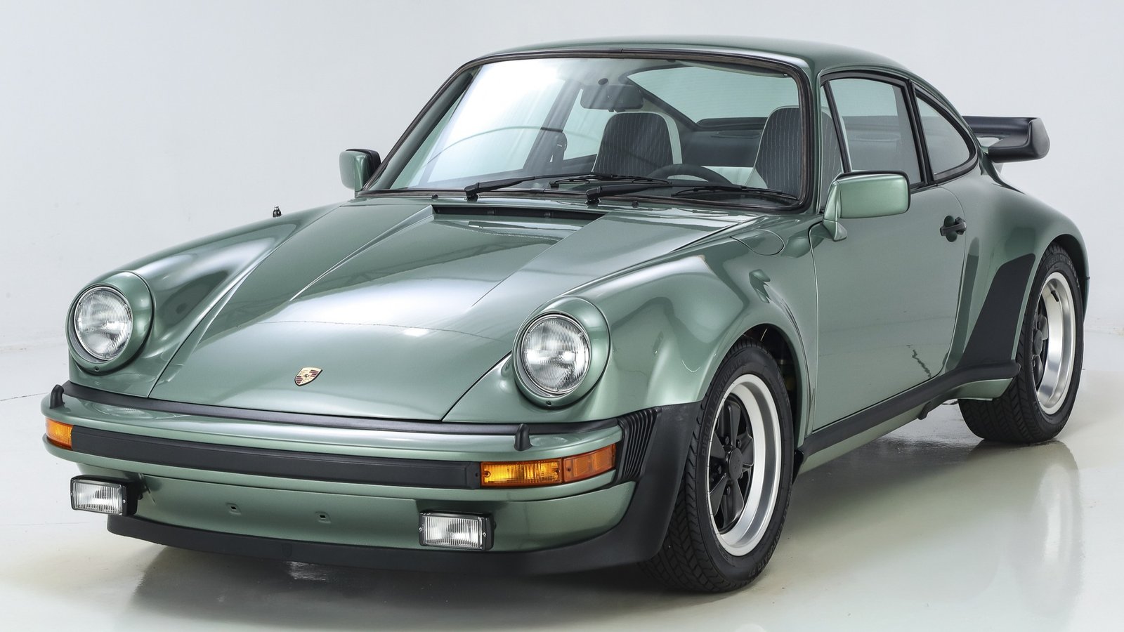 Green 1978 Porsche 930 Turbo in a studio, front three-quarter view