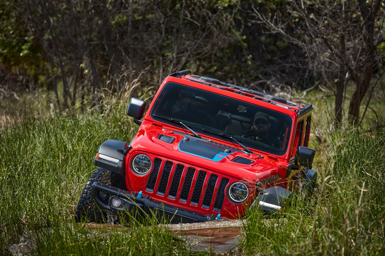 Red Jeep Wrangler Rubicon 4xe fording a stream