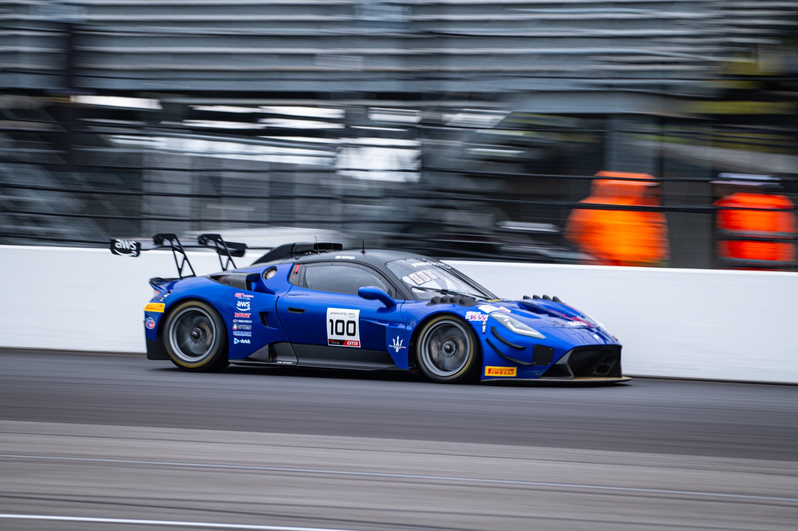 Side view of the No. 100 Maserati GT2 at speed on the Indianapolis road course