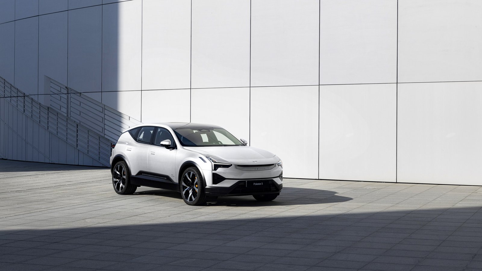 White Polestar 3 electric SUV parked beside a white modern building