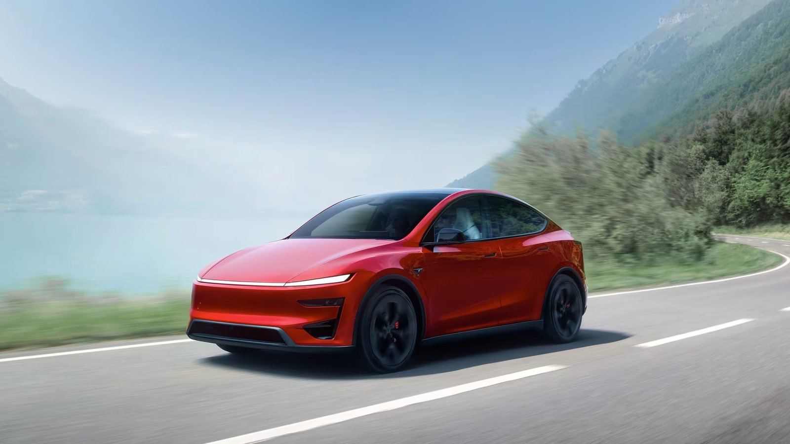 Red Tesla Model Y Performance driving on a mountain road
