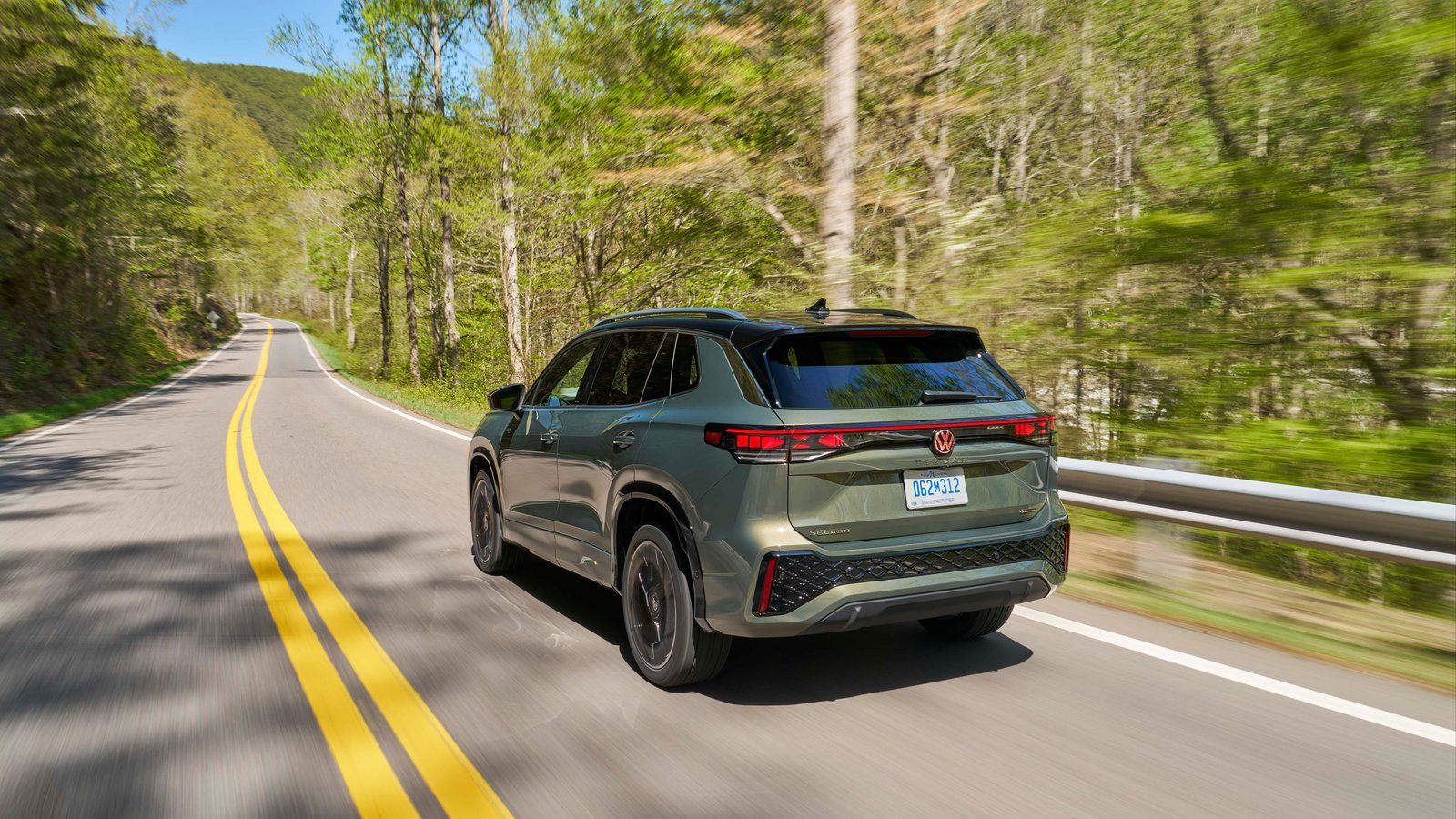 2026 Volkswagen Tiguan SEL R-Line Turbo rear three-quarter view driving on a forest road