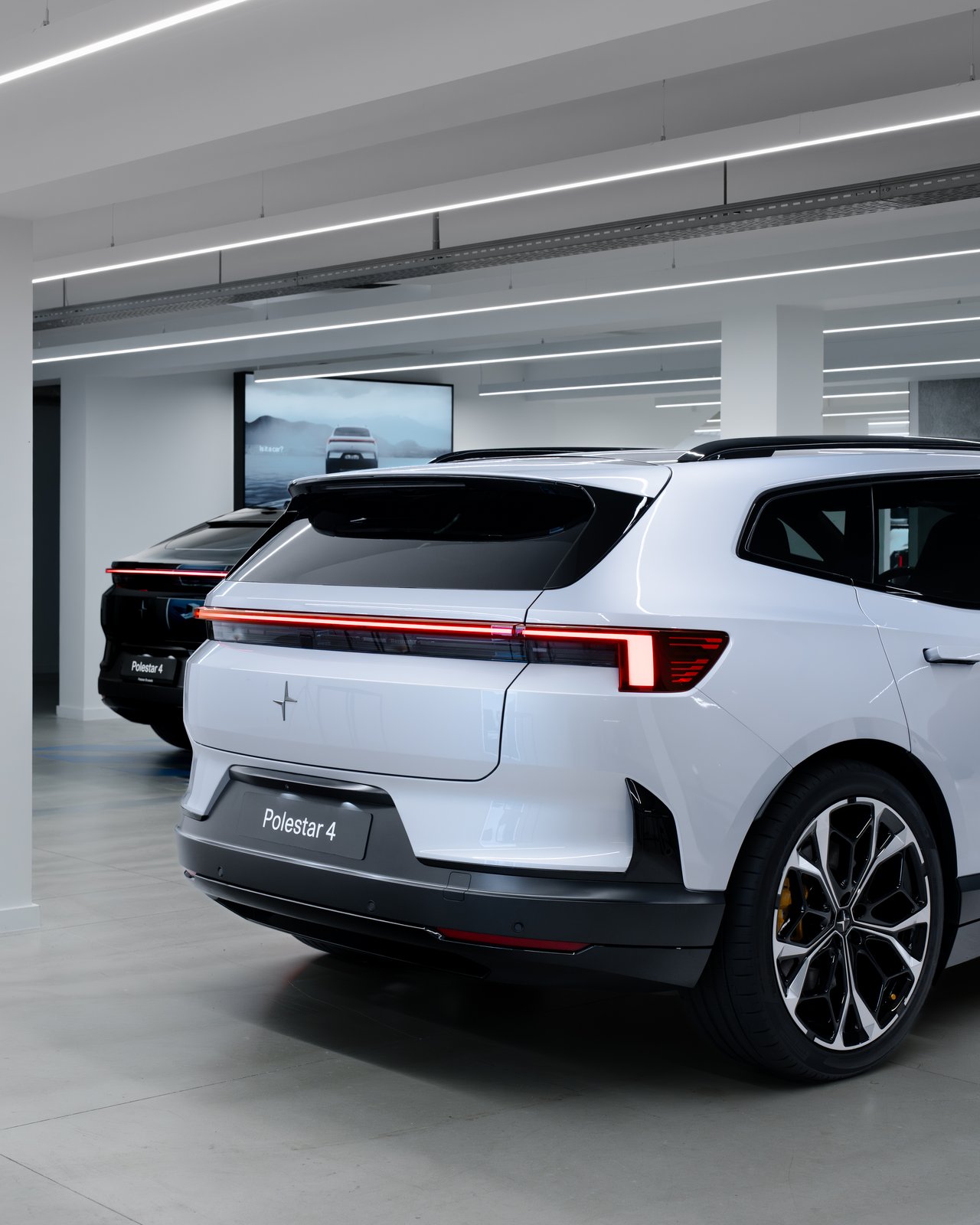 White Polestar 4 SUV rear view with black Polestar 4 coupe behind