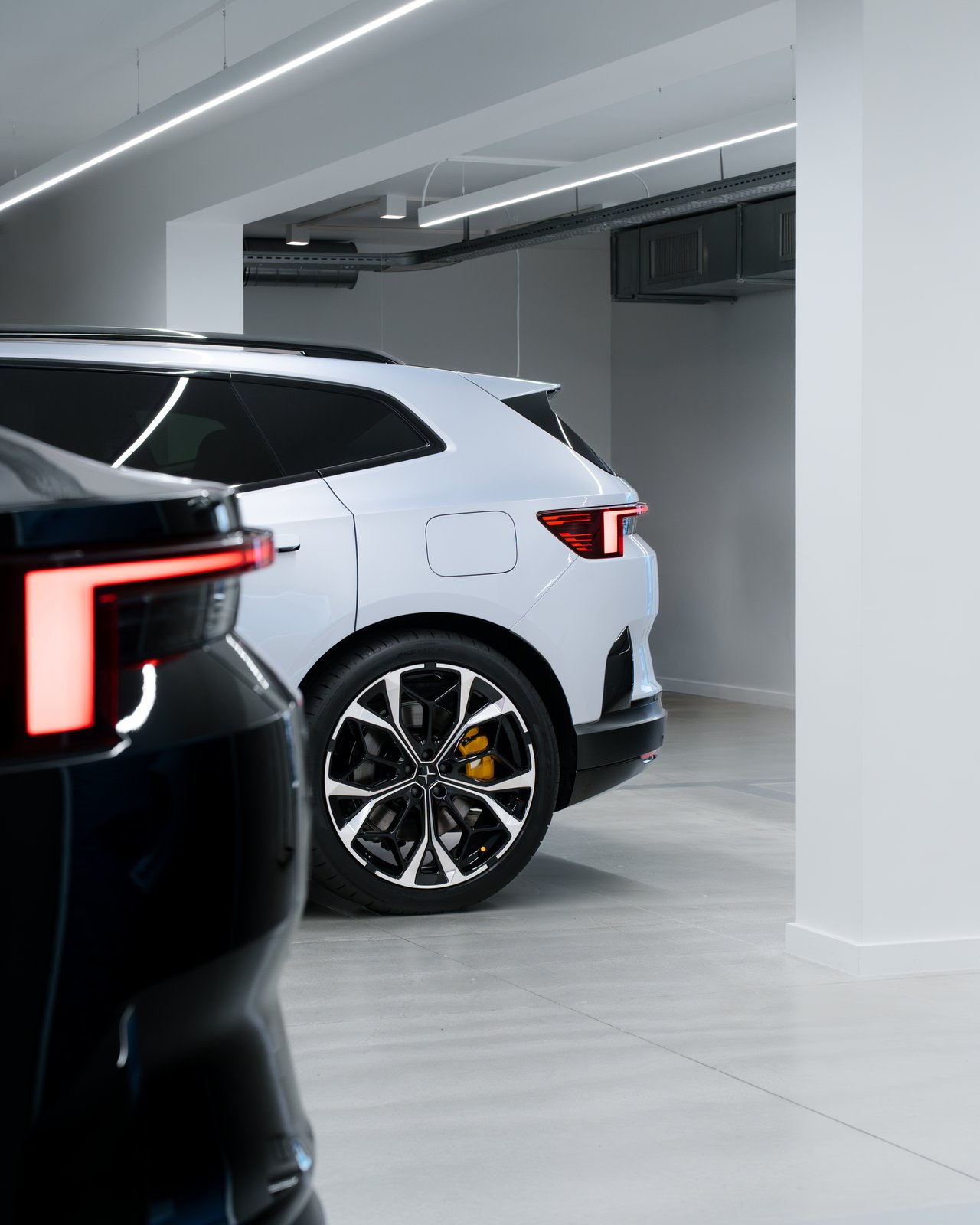 Polestar 4 SUV rear quarter in profile beside a Polestar 4 coupe taillight
