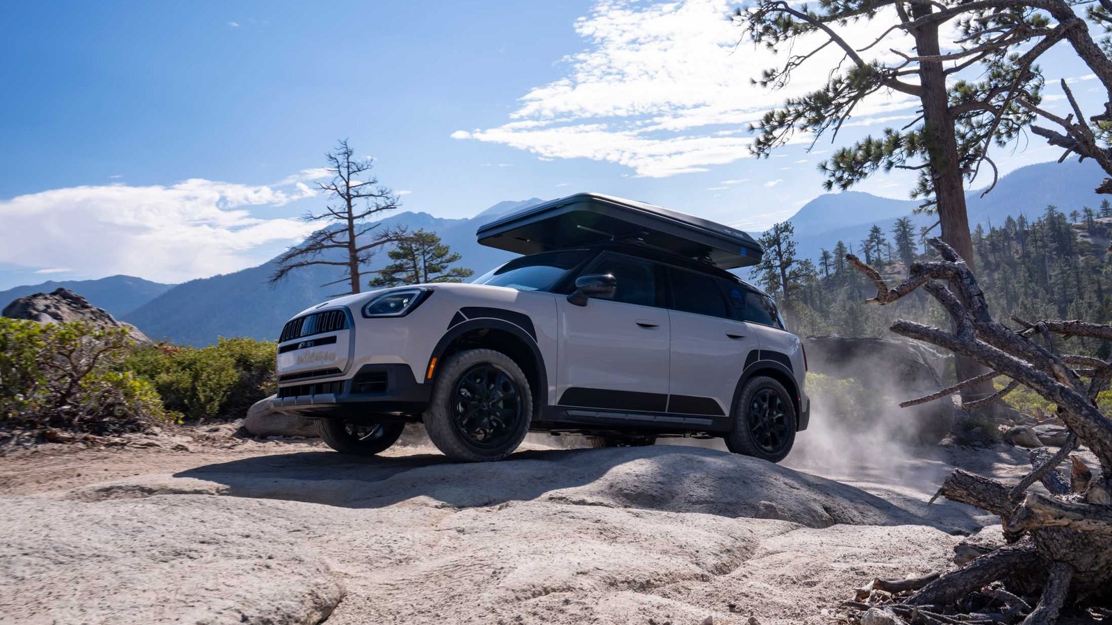 White MINI Countryman Untamed Edition with a hard-shell roof tent on a trail