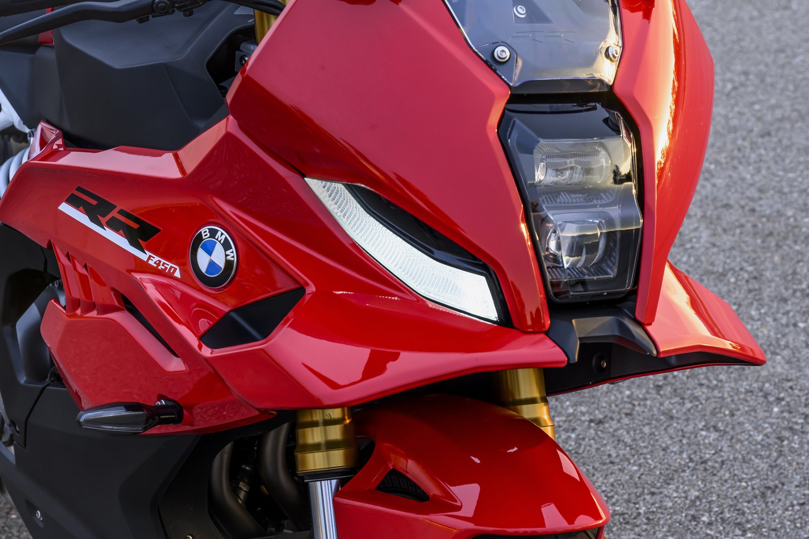 Close-up of the BMW F 450 RR’s LED headlight, winglet and gold fork