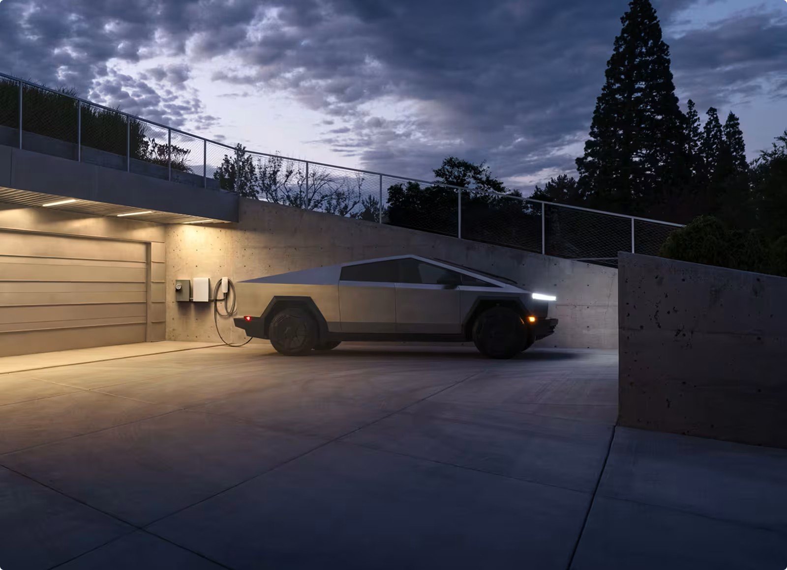 Tesla Cybertruck charging in a driveway at dusk