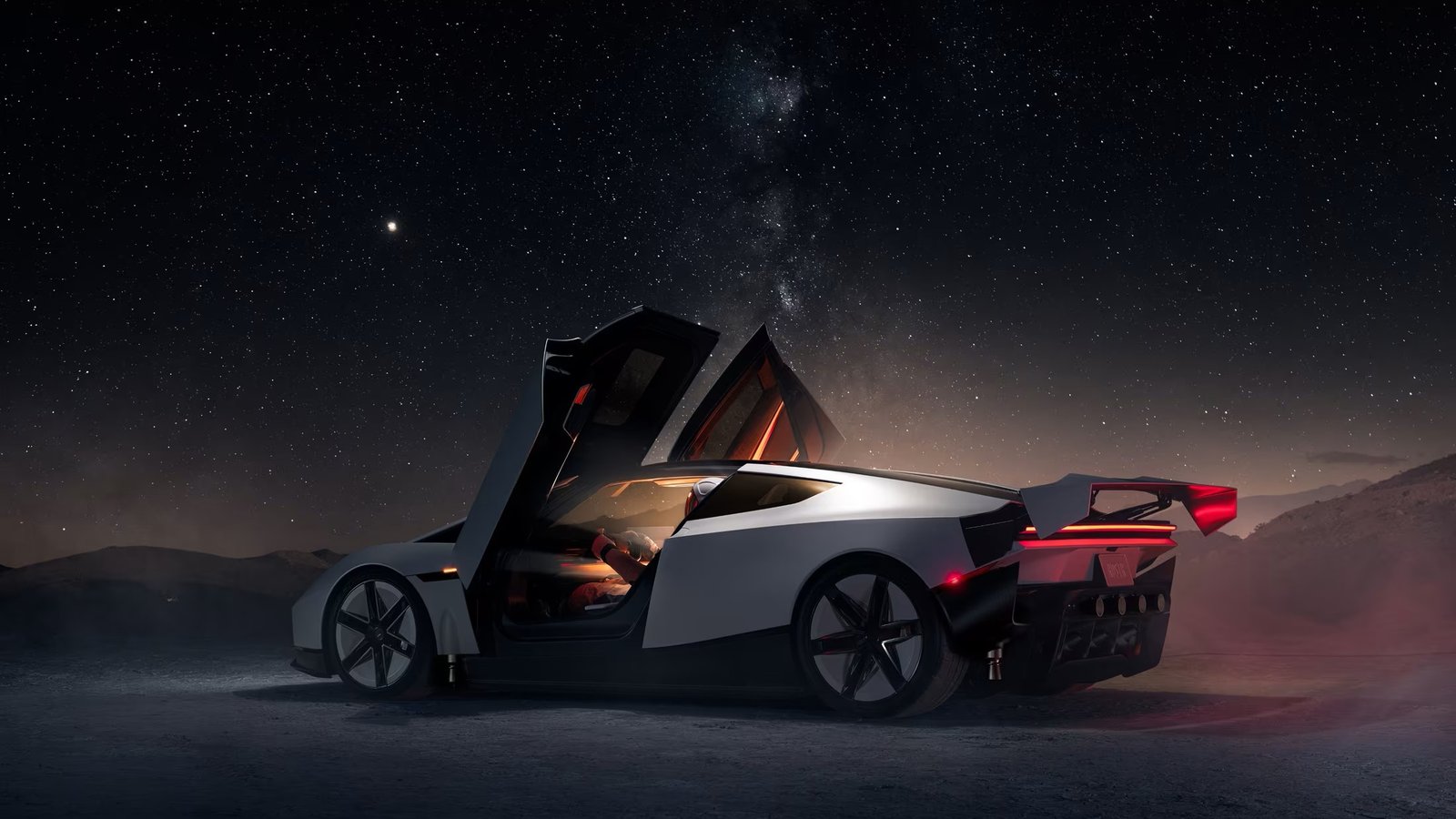 Tesla Roadster at night with upward-opening doors and rear wing deployed