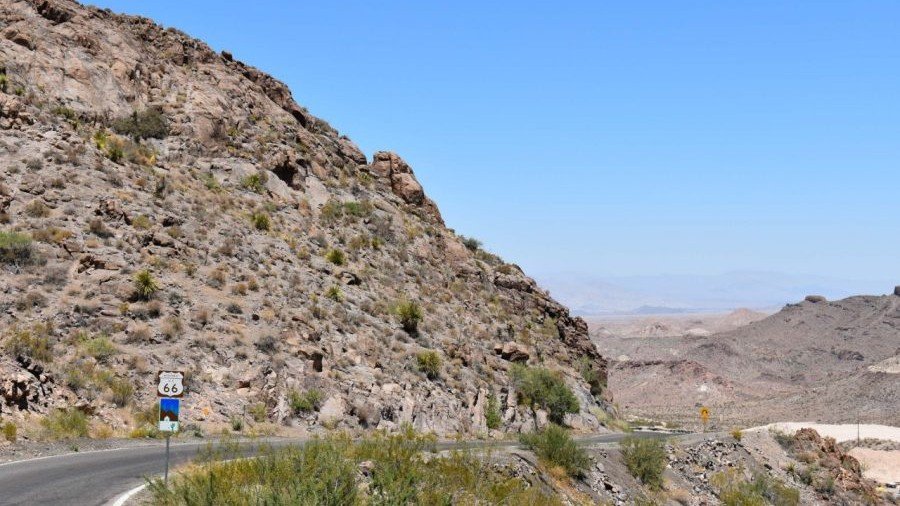 Historic Route 66 sign on a winding desert mountain road