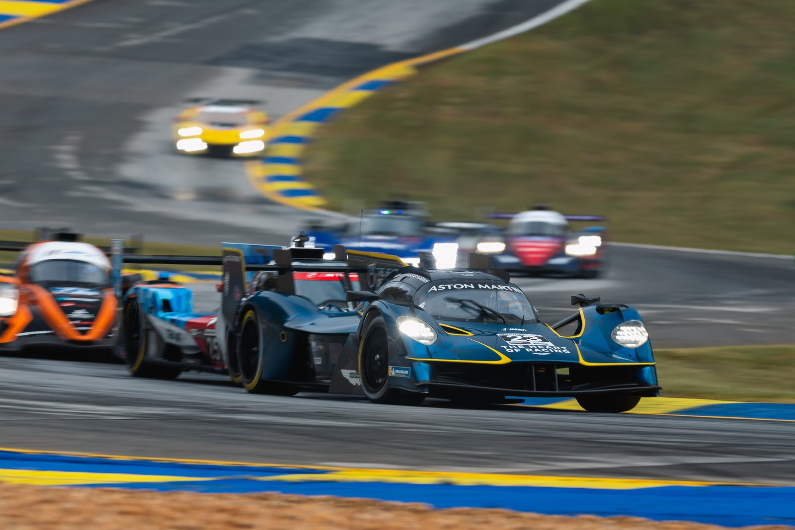 Aston Martin Valkyrie hypercar racing in traffic at Road Atlanta