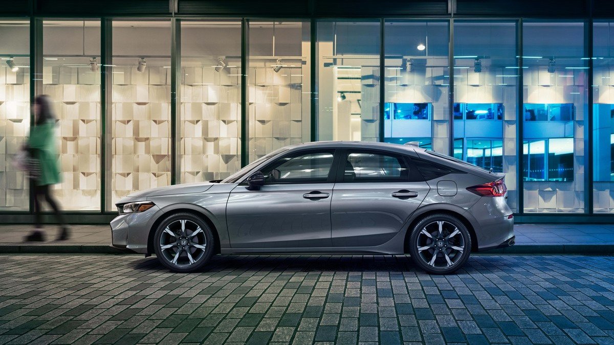 Gray 2027 Honda Civic Hatchback parked on a city street, side profile