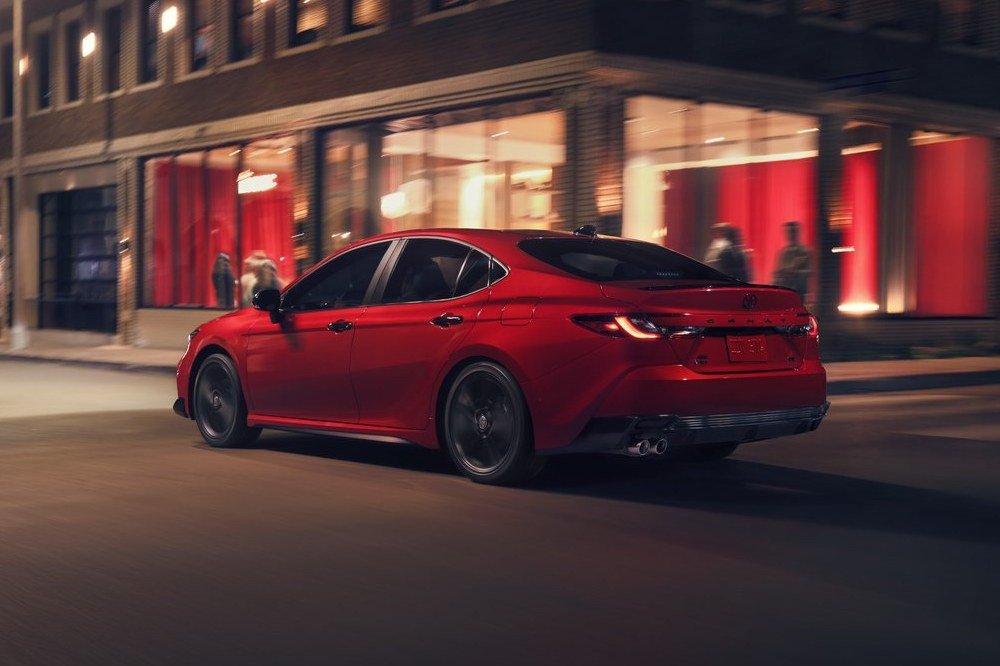 Red 2027 Toyota Camry Nightshade parked on a city street at dusk