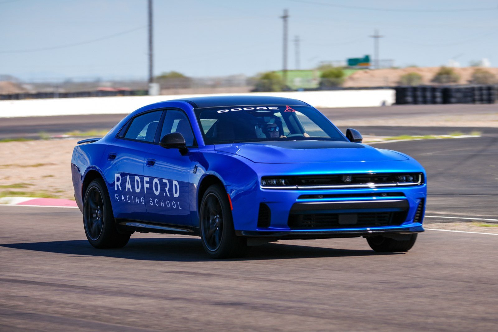 Blue four-door Dodge Charger in Radford Racing School livery on track