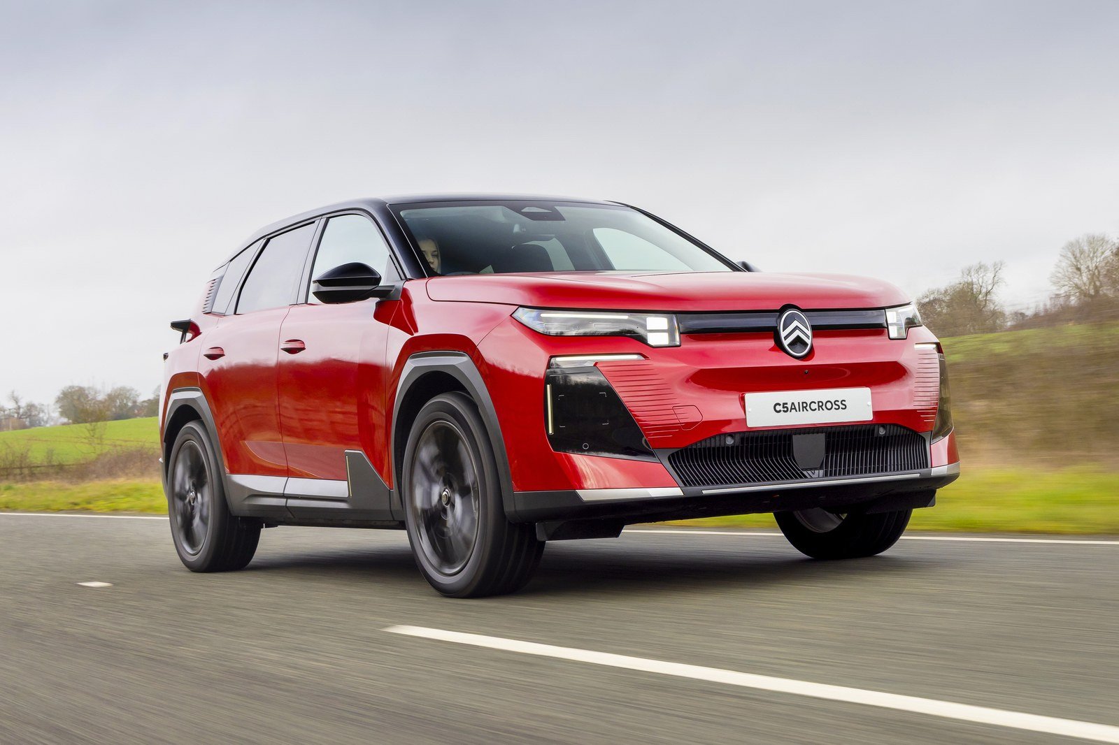 Red Citroën C5 Aircross driving on a country road