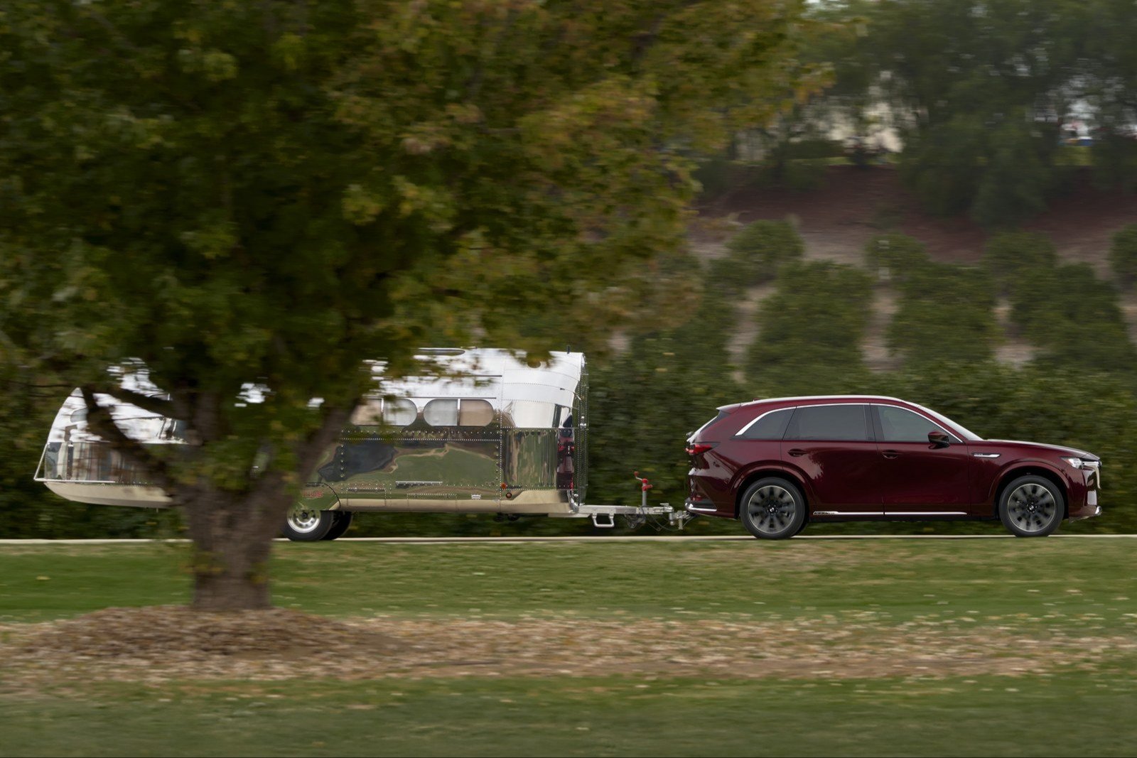 Mazda CX-90 towing a polished aluminum travel trailer