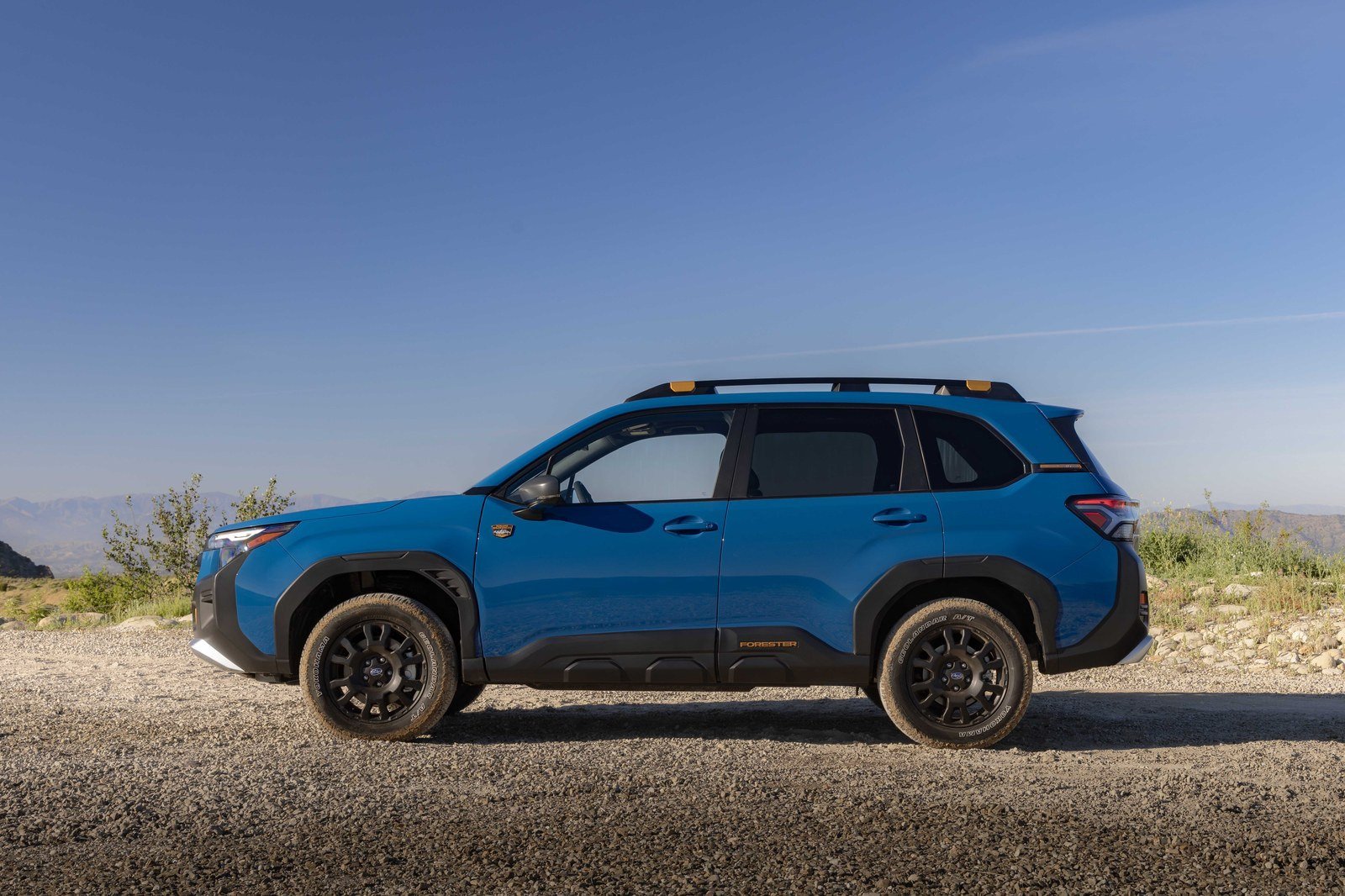 Blue Subaru Forester Wilderness Hybrid in profile on gravel