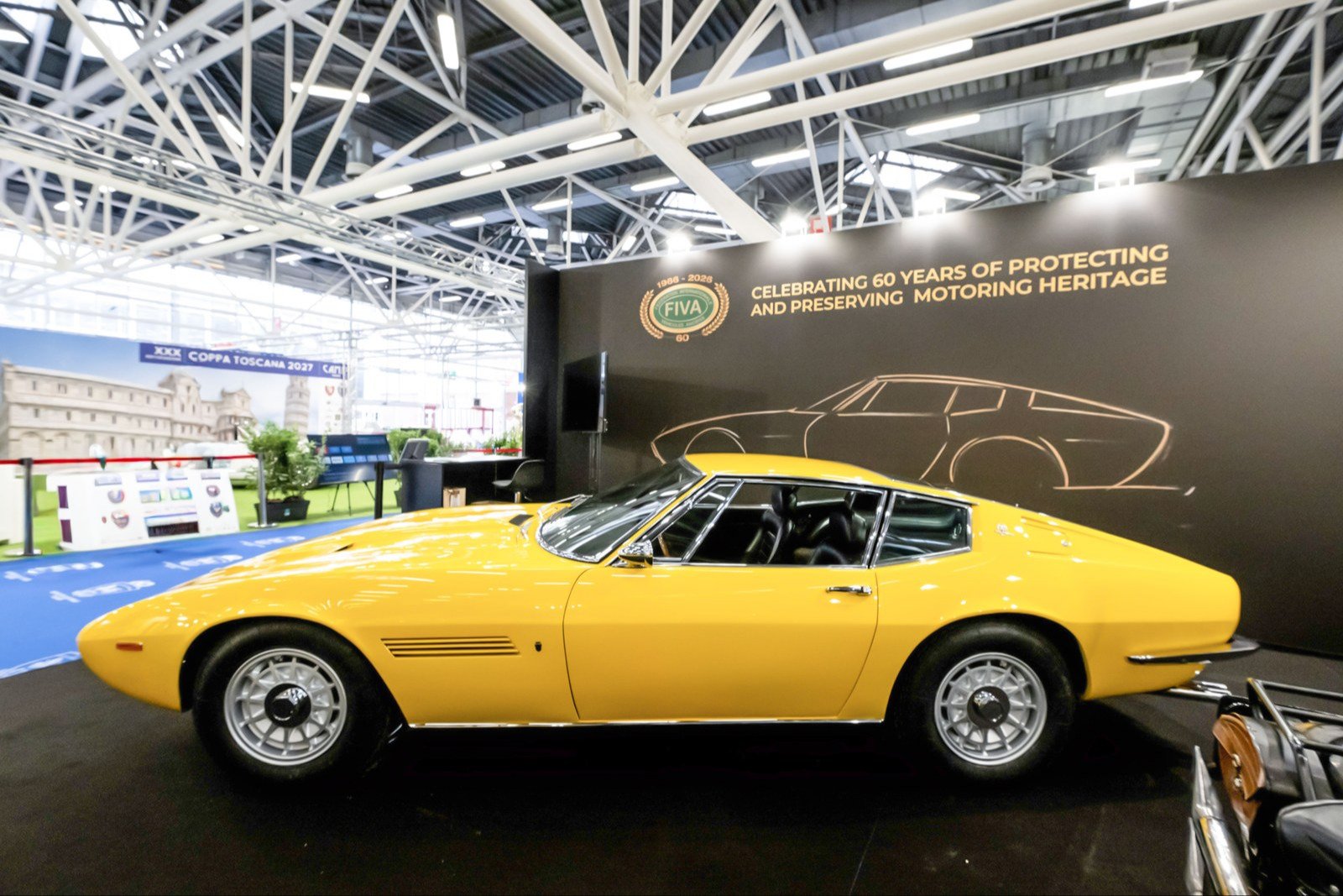 Yellow 1970 Maserati Ghibli SS in profile on the FIVA stand