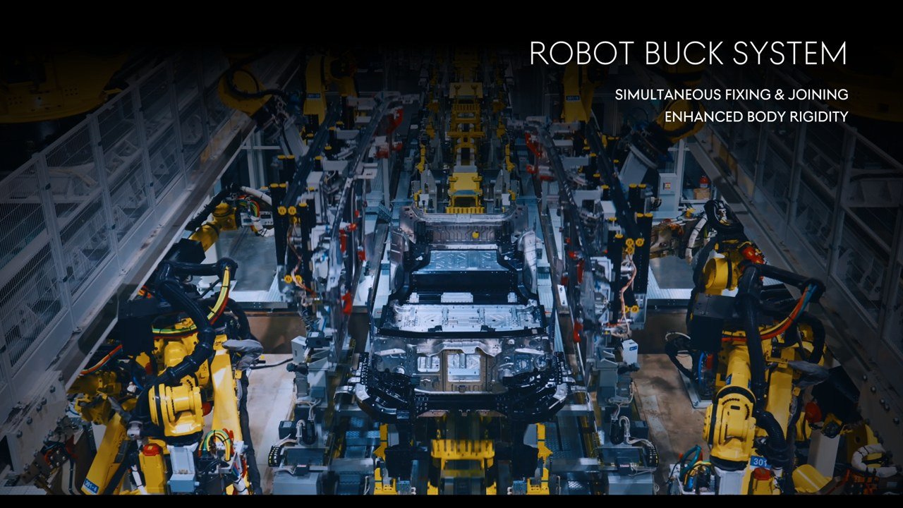 Yellow robots joining a GV90 body in a robotic buck