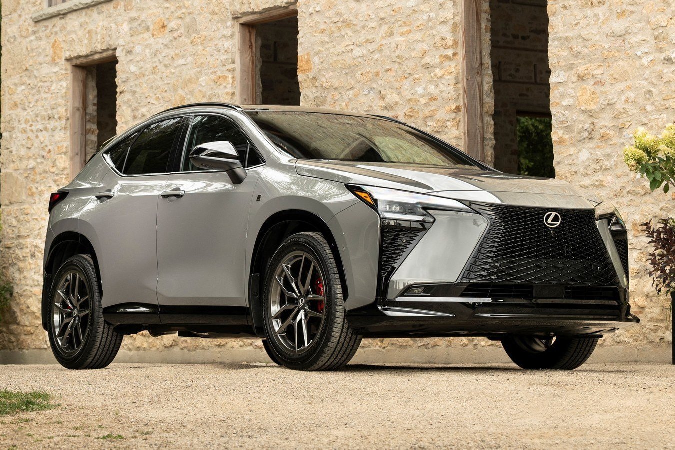 Silver 2027 Lexus NX 350h F SPORT parked beside a stone wall
