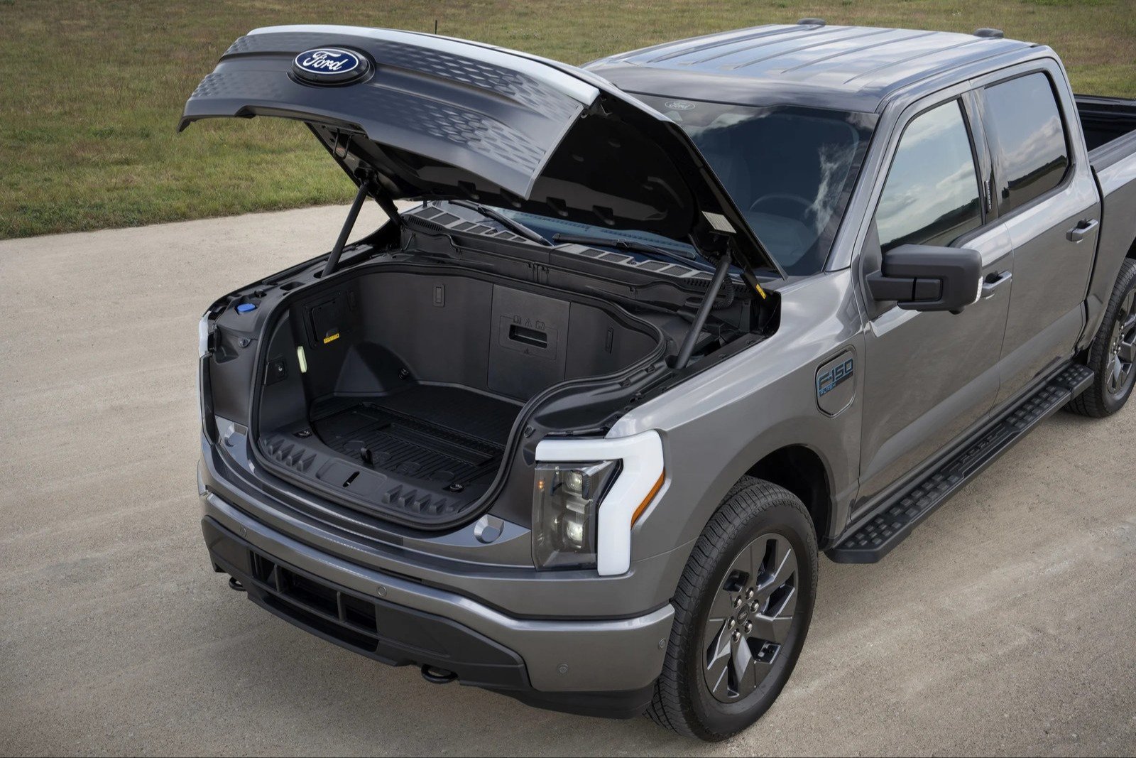 Open front trunk of a gray Ford F-150 Lightning Flash