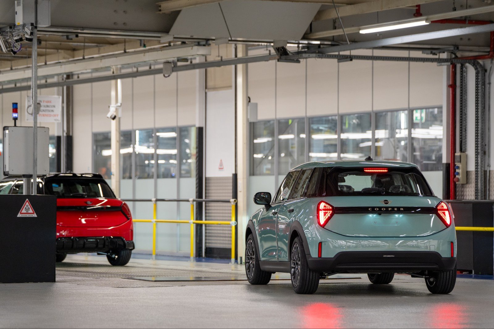Teal MINI Cooper 5-door with lit taillights in an Oxford plant bay
