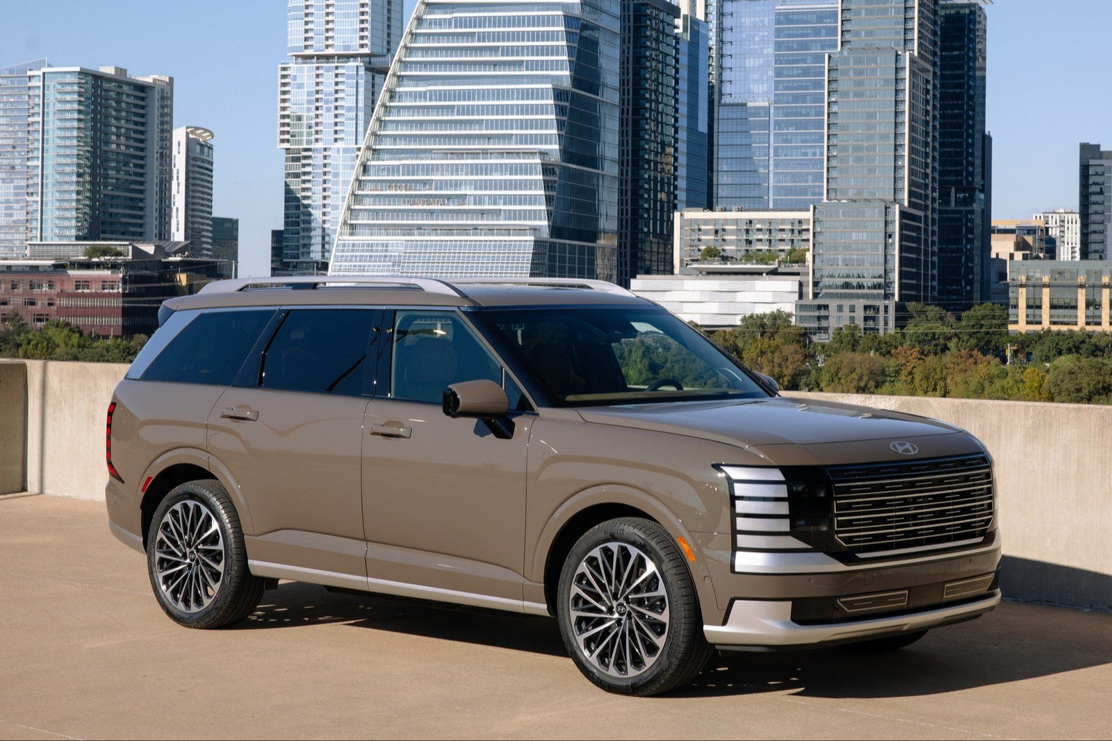 Hyundai Palisade Hybrid Calligraphy parked on a rooftop with the Austin skyline behind
