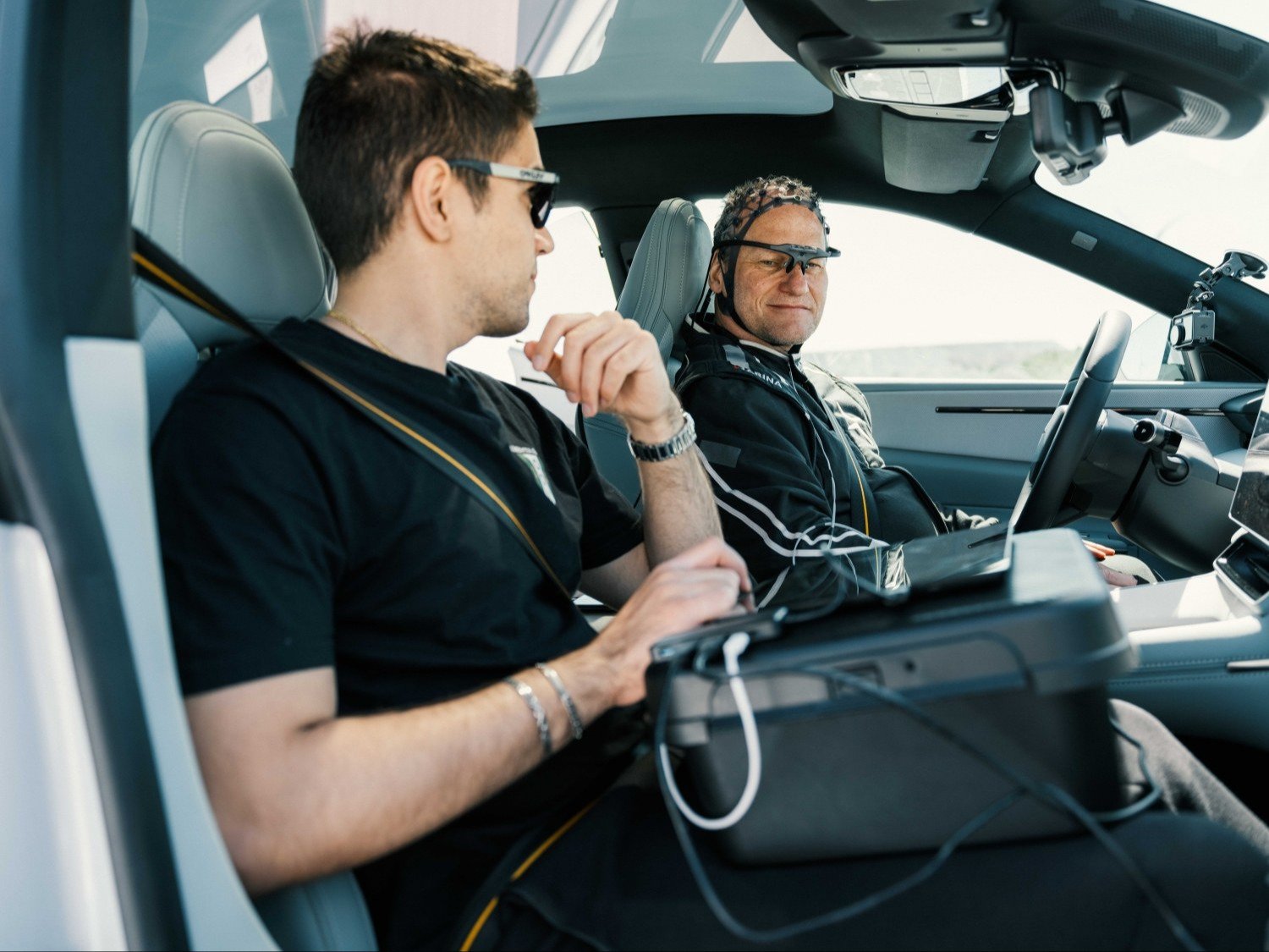 Researcher with laptop beside a driver wearing eye-tracking glasses