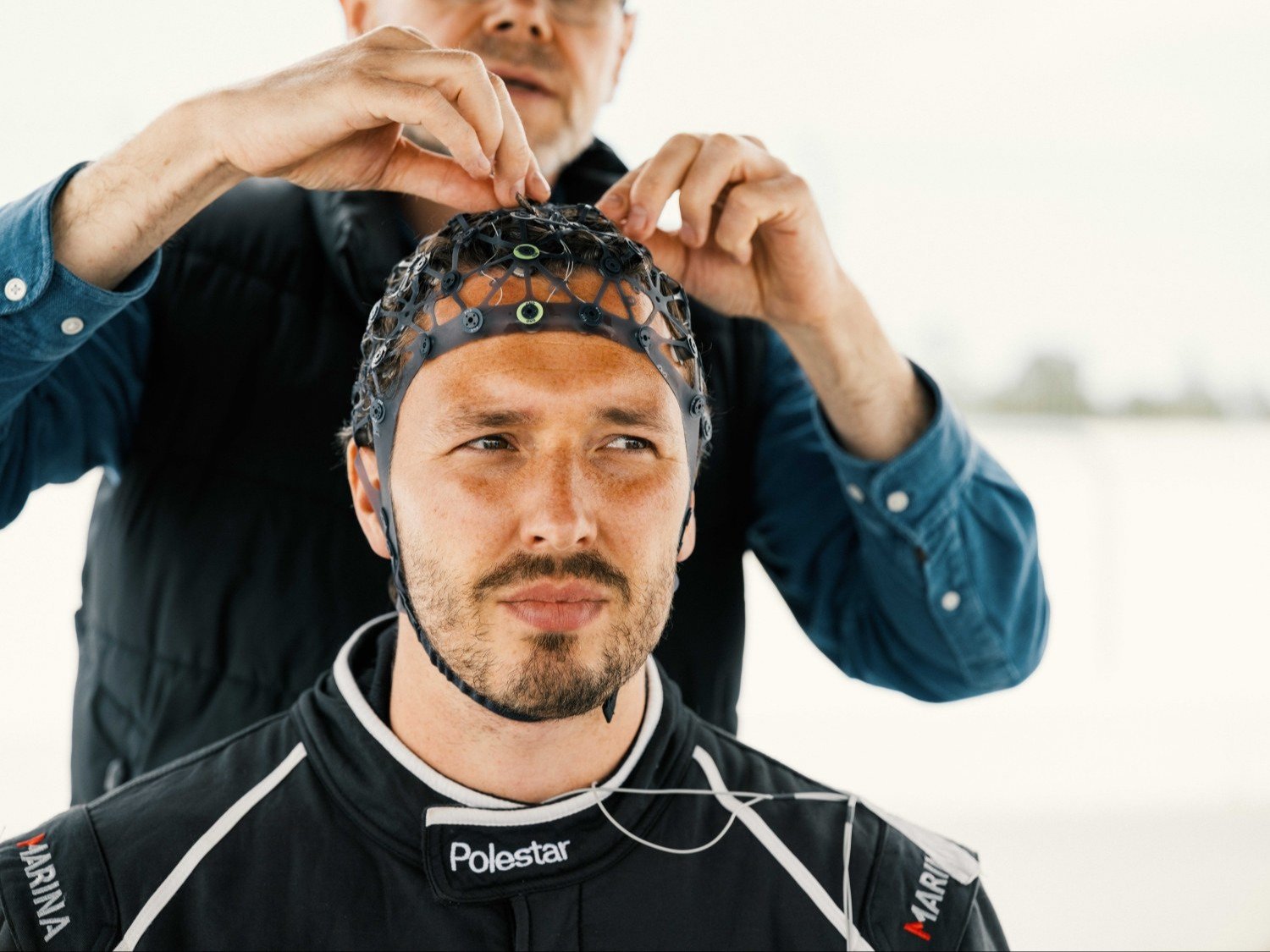 Driver in Polestar race suit being fitted with a sensor cap