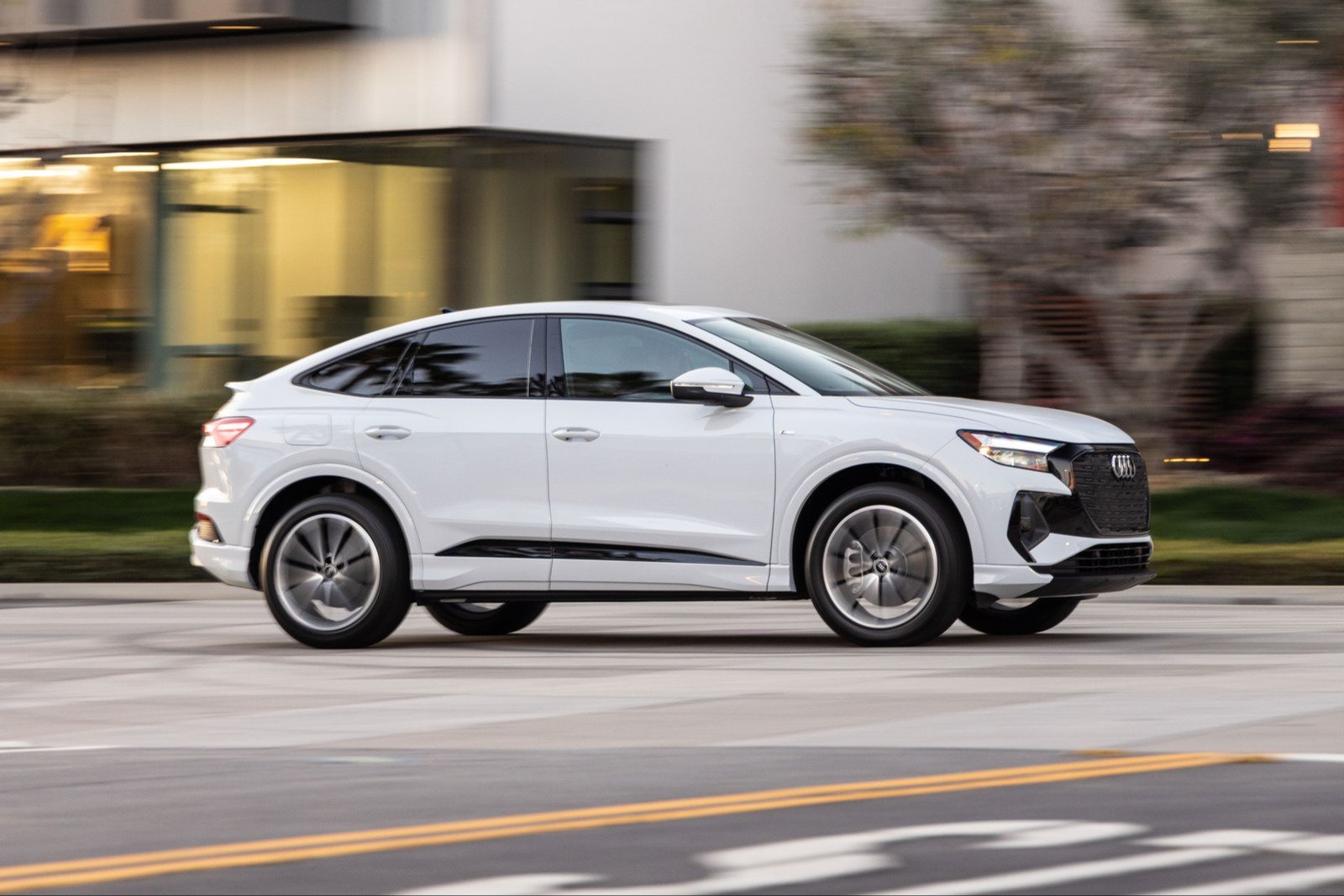White Audi Q4 Sportback e-tron driving on a city street