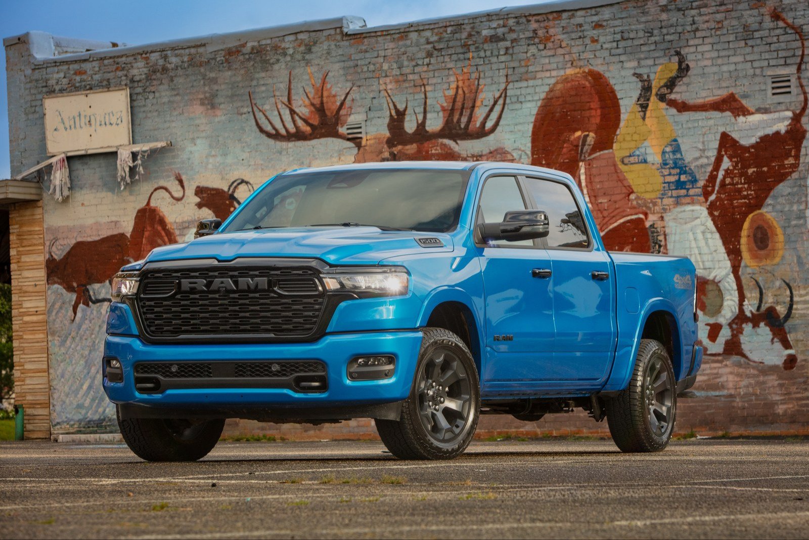 Blue 2026 Ram 1500 crew cab in front of a painted brick wall