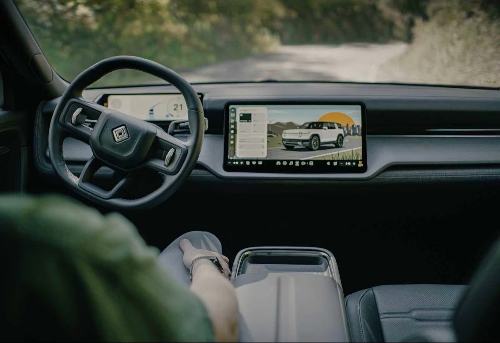 Rivian R2 interior with hands-free driving engaged, hands off the wheel