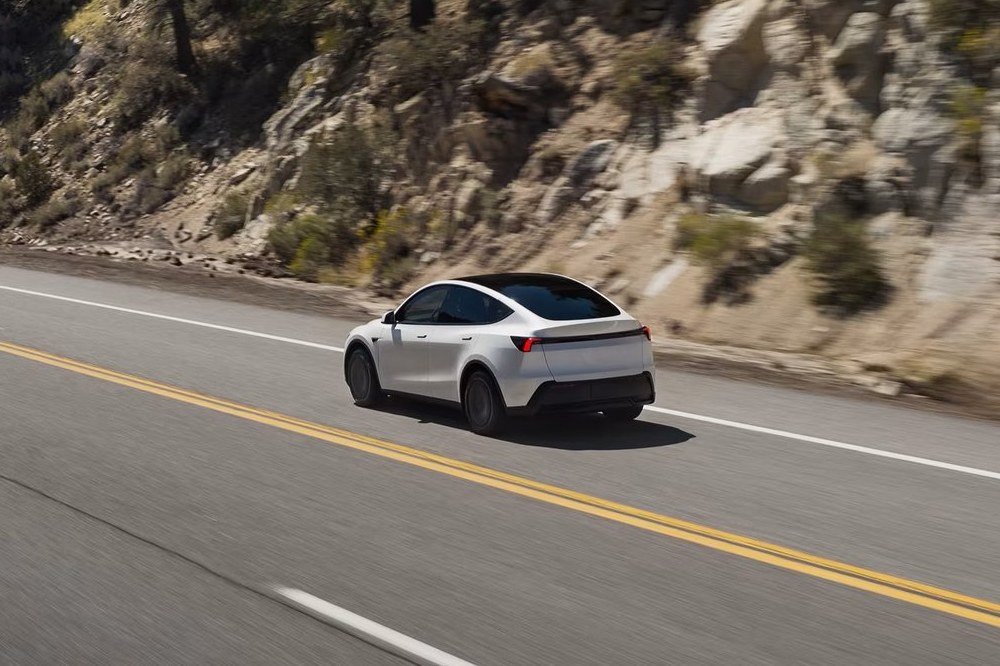White Tesla Model Y on a two-lane highway