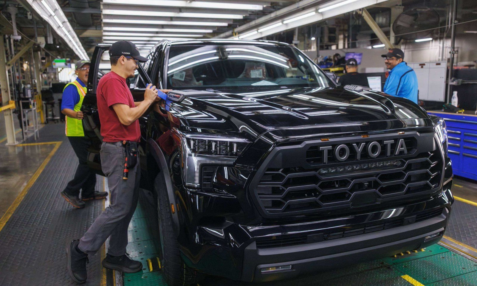 Workers inspect a black Toyota on the San Antonio assembly line