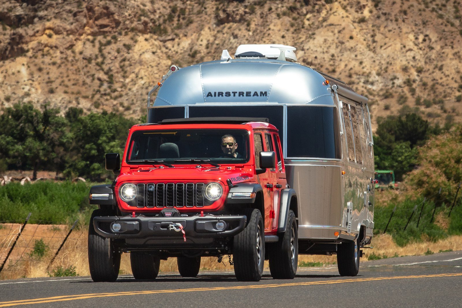 Red Jeep Wrangler Rubicon towing an Airstream travel trailer